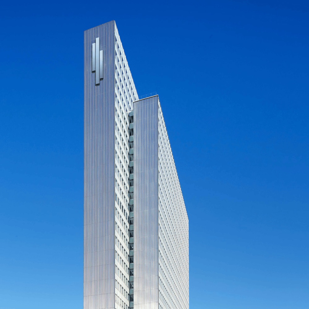 Fassade des Dreischeibenhaus-Hochhauses in Düsseldorf – Stahl-Glas-Architektur vor blauem Himmel